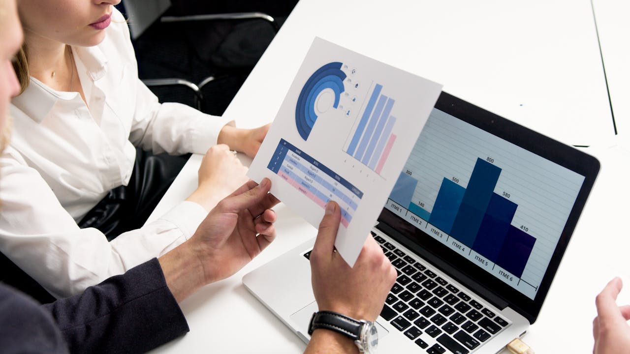 Mastering the First Impression: Your intriguing post title goes here Business professionals discussing data charts and graphs in a modern office setting.